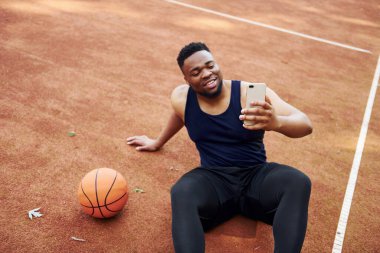 Selfie yapıyorum. Afrikalı Amerikalı adam dışarıda basketbol oynuyor..