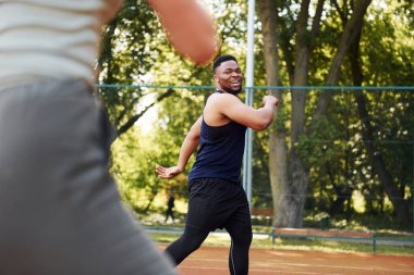 Kız arkadaşı olan Afrikalı Amerikalı bir adam dışarıda basketbol oynuyor..