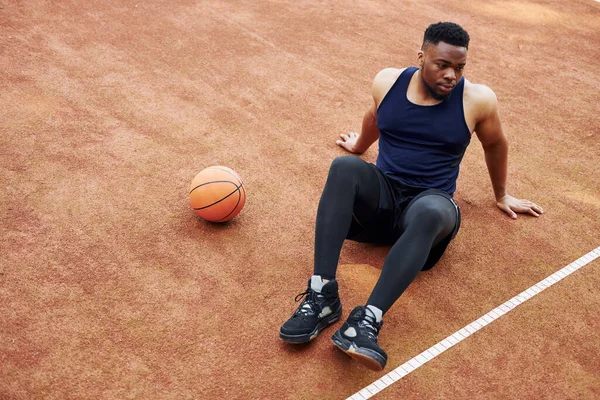 Müder Afrikanisch Amerikanischer Mann Sitzt Auf Dem Boden Mit Ball — Stockfoto