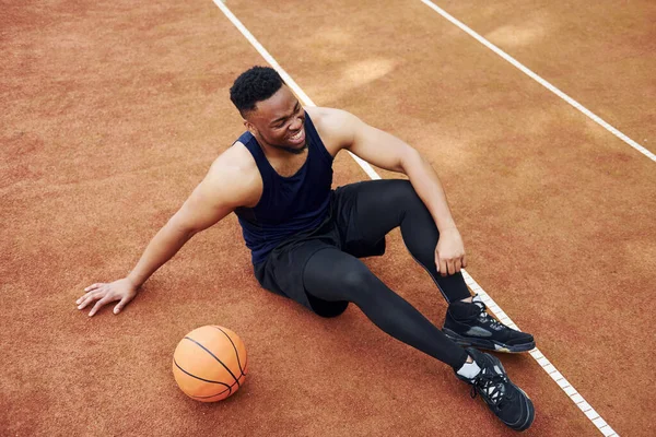Müder Afrikanisch Amerikanischer Mann Sitzt Auf Dem Boden Mit Ball — Stockfoto