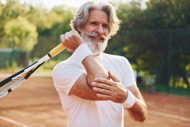 Travma yüzünden acı çekiyor. Son sınıf modern stil adamı gündüz vakti spor sahasında..