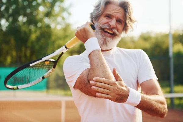 Travma yüzünden acı çekiyor. Son sınıf modern stil adamı gündüz vakti spor sahasında..
