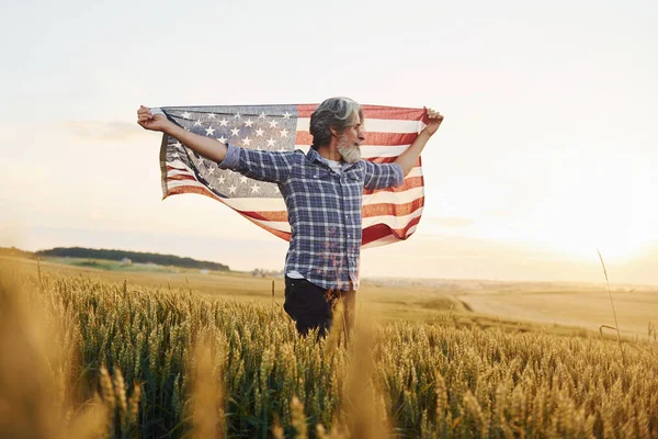 手里拿着美国国旗农场中留着白发大胡子的有爱国心的老年男子 — 图库照片