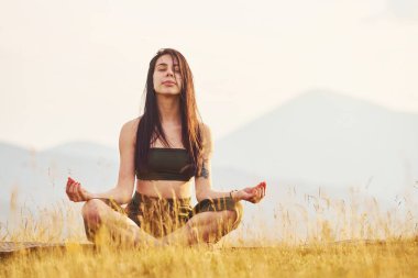 Yoga egzersizi yapan güzel bir genç kadın. Majestic Karpat Dağları. Dokunulmamış doğanın güzel manzarası.