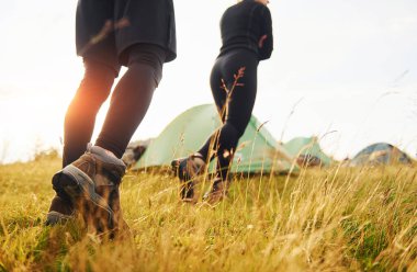 Yeşil çadırın yanında yürüyüş yapan bir çift. Seyahat kavramı.