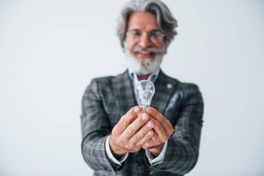 Ellerinde ampulle. Gri saçlı ve sakallı son sınıf modacı modern adam..