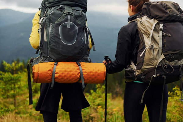 View from behind of young travelers. Majestic Carpathian Mountains. Beautiful landscape of untouched nature.