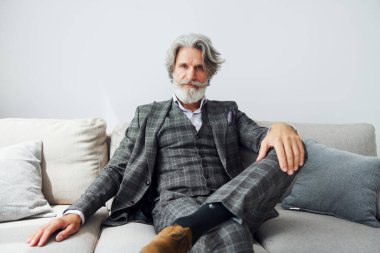 Zarif kıyafetlerle apartmanda. Gri saçlı ve sakallı son sınıf modacı modern adam..
