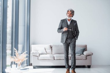 Zarif kıyafetlerle apartmanda. Gri saçlı ve sakallı son sınıf modacı modern adam..