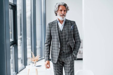 Odada dikiliyorum. Gri saçlı ve sakallı son sınıf modacı modern adam..