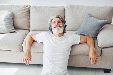 Müzikten hoşlanıyor. Gri saçlı ve sakallı son sınıf modacı modern adam..