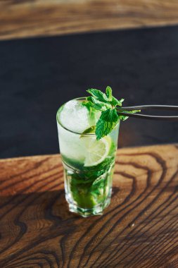 Tahta masada alkolsüz mojito kokteylinin taze yaz manzarasını kapat..