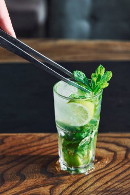 Tahta masada alkolsüz mojito kokteylinin taze yaz manzarasını kapat..