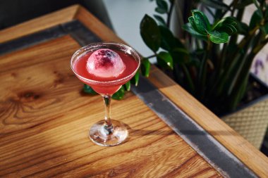 Kırmızı renkli. Tahta masada taze yaz kokteylinin yakın görüntüsü..