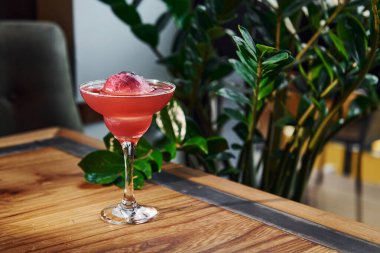 Kırmızı renkli. Tahta masada taze yaz kokteylinin yakın görüntüsü..