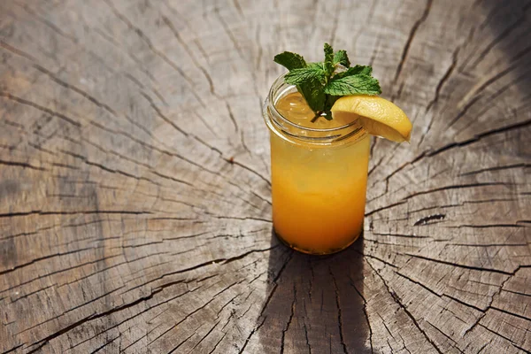 加柠檬和薄荷坐在木制桌子上的夏季新鲜酒精鸡尾酒近景 — 图库照片