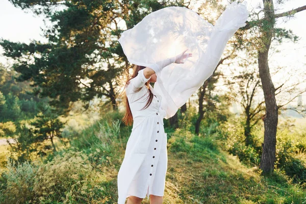 森の中で白い布を手に屋外で踊る幸せな若い女性 — ストック写真