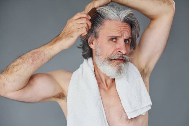 Yüz ve cilt temizliği ile ilgileniyor. Gri saçlı ve sakallı modern son sınıf öğrencisi içeride..