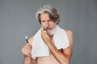 Tıraş olma kavramı. Gri saçlı ve sakallı modern son sınıf öğrencisi içeride..