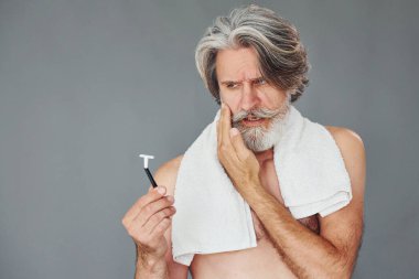 Tıraş olma kavramı. Gri saçlı ve sakallı modern son sınıf öğrencisi içeride..