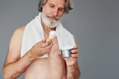 Tıraş jölesiyle. Gri saçlı ve sakallı modern son sınıf öğrencisi içeride..