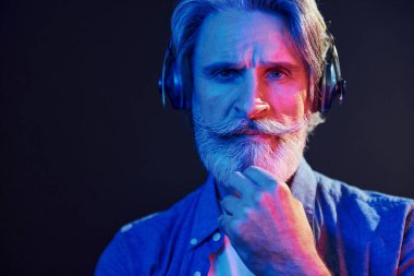 Güzel neon ışıklar. Gri saçlı ve sakallı modern son sınıf öğrencisi içeride..