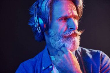 Güzel neon ışıklar. Gri saçlı ve sakallı modern son sınıf öğrencisi içeride..