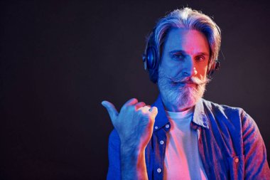 Güzel neon ışıklar. Gri saçlı ve sakallı modern son sınıf öğrencisi içeride..