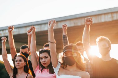 Yumruklar yükseğe fırladı. Birlikte duran bir grup protestocu genç. İnsan hakları eylemcisi veya hükümete karşı..