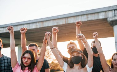 Yumruklar yükseğe fırladı. Birlikte duran bir grup protestocu genç. İnsan hakları eylemcisi veya hükümete karşı..