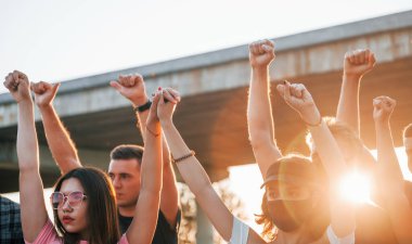 Yumruklar yükseğe fırladı. Birlikte duran bir grup protestocu genç. İnsan hakları eylemcisi veya hükümete karşı..