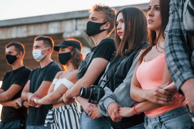 Kameralı fotoğrafçı. Birlikte duran bir grup protestocu genç. İnsan hakları eylemcisi veya hükümete karşı..