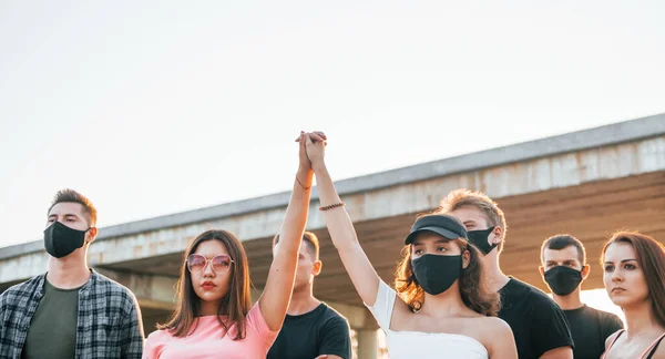 拳が高く上がった 一緒に立っている若い人たちに抗議するグループ 人権活動家又は政府に対する活動家 — ストック写真
