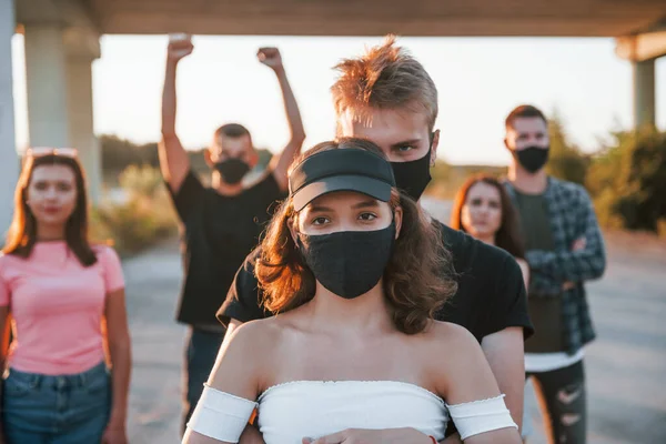 Ett Par Som Omfamnar Varandra Gruppen Protesterande Unga Människor Som — Stockfoto