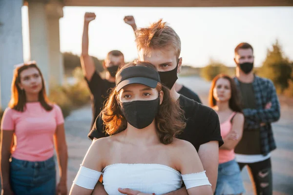 Пара Обнимает Друг Друга Группа Протестующих Молодых Людей Которые Стоят — стоковое фото