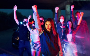 Sigara, yumruk, polis. Birlikte duran bir grup protestocu genç. İnsan hakları eylemcisi veya hükümete karşı..