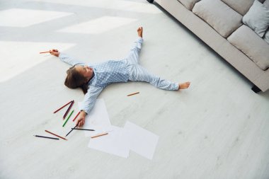 Kalem ve kağıtla. Evde tek başına yaratıcı, sevimli küçük bir kız. Çocuk hafta sonu eğleniyor.