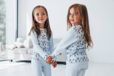 Birbirimizin elini tutuyoruz. Evde birlikte oturan iki küçük tatlı kız. Çocuklar eğleniyor..