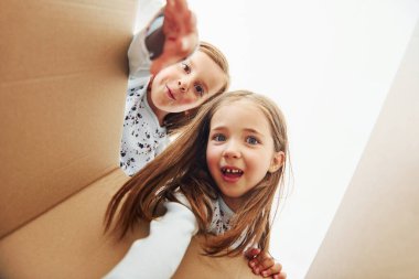 Karton kutunun içine bakıyorum. Evde birlikte oturan iki küçük tatlı kız. Çocuklar eğleniyor..