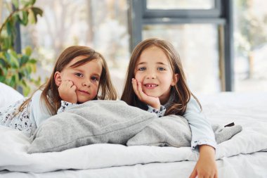 Yatağa uzanıp kameraya bakmak. Evde birlikte oturan iki küçük tatlı kız. Çocuklar eğleniyor..