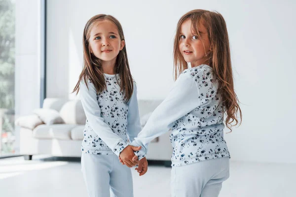 Birbirimizin elini tutuyoruz. Evde birlikte oturan iki küçük tatlı kız. Çocuklar eğleniyor..