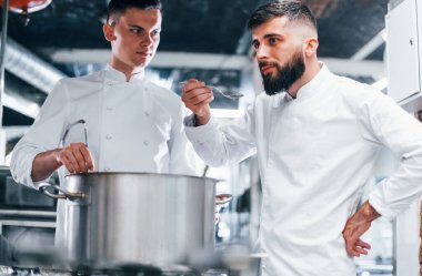 Diğer çalışanların yardımıyla. Mutfakta yemek pişiren beyaz üniformalı bir şef. İşte yoğun bir gün..