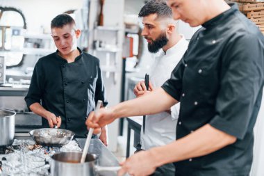 Mutfakta birlikte yemek pişiren bir grup insan. İşte yoğun bir gün..