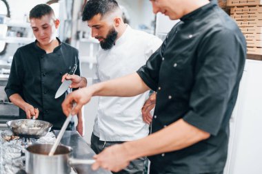 Mutfakta birlikte yemek pişiren bir grup insan. İşte yoğun bir gün..