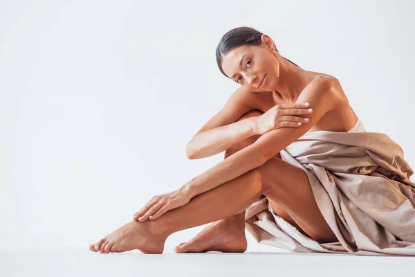Sitzt Und Bedeckt Den Körper Mit Einem Tuch Schöne Frau — Stockfoto