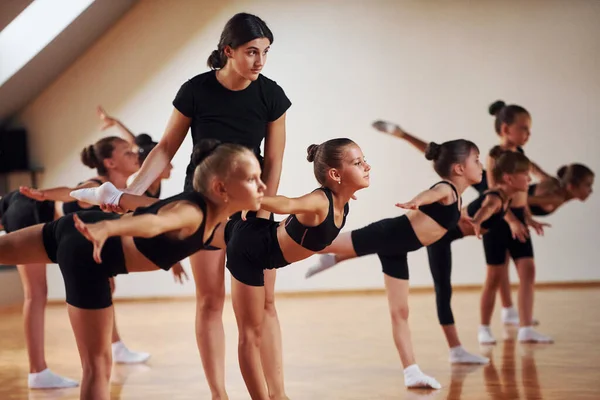 Coach Helping Group Female Kids Practicing Athletic Exercises Together Indoors — Stock Photo, Image