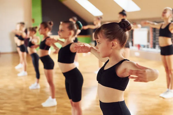 Der Reihe Stehend Gruppe Weiblicher Kinder Praktiziert Gemeinsam Sportliche Übungen — Stockfoto