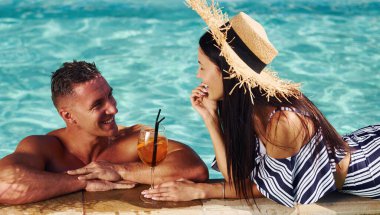 Mutlu bir çift ya da tatilde yüzme havuzunda birlikte olan arkadaşlar..