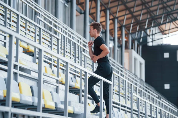 階段を走っている スポーツ若いです男で黒シャツとパンツ屋外で昼間 — ストック写真