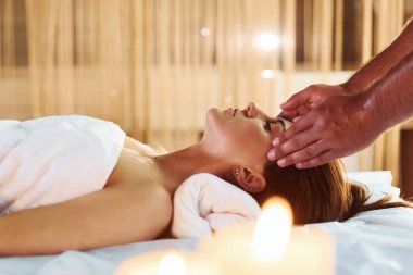 Beyaz havluyla içeri giren genç bayana masaj yapan adam..